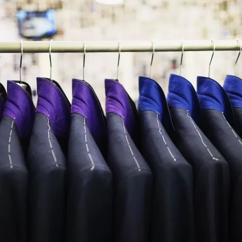 Close-up of suits hanging on rack in designer showroom